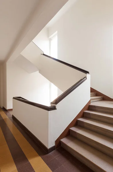 Коричневая лестница, белая стена и большие окна — стоковое фото