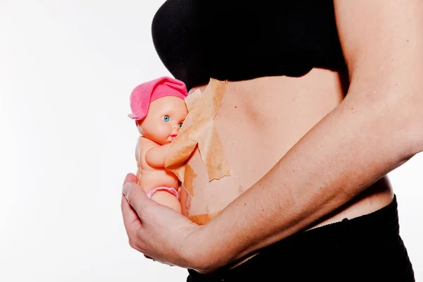 Detalhe da barriga grávida com boneca feminina — Fotografia de Stock