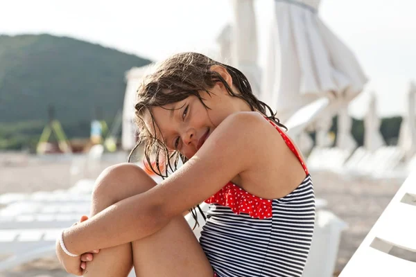 坐在沙滩上的躺椅上的小女孩 — 图库照片