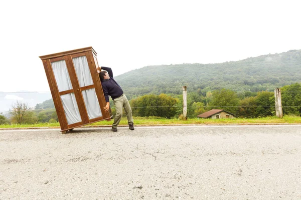 Homem move armários, está fazendo um movimento — Fotografia de Stock