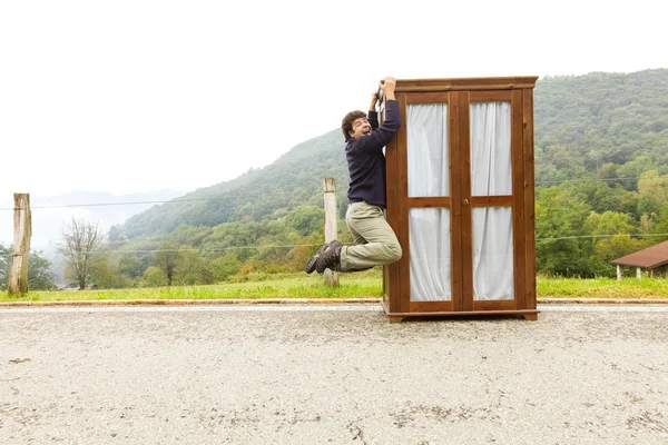 Homem move armários, está fazendo um movimento — Fotografia de Stock