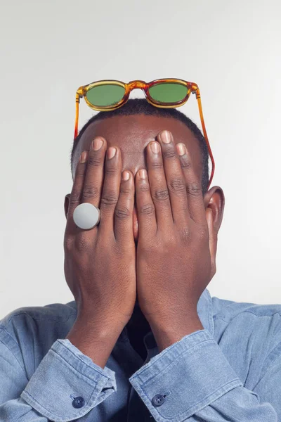 Afrikanischer Junge versteckt ihr Gesicht hinter ihren Händen — Stockfoto