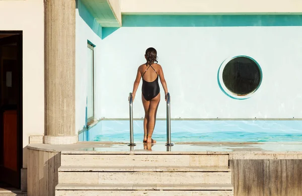 Junges Mädchen läuft am Rande eines Schwimmbades — Stockfoto