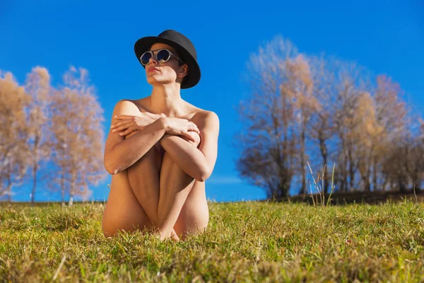 Chica desnuda sentada en la hierba con las piernas cruzadas, concepto —  Fotos de Stock