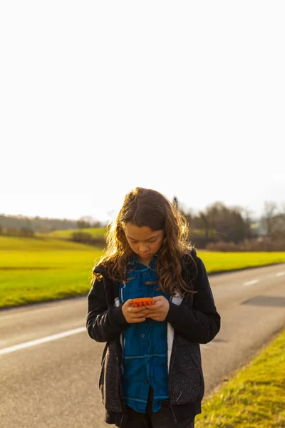 Girl using the phone on the street, danger — Stock Photo, Image