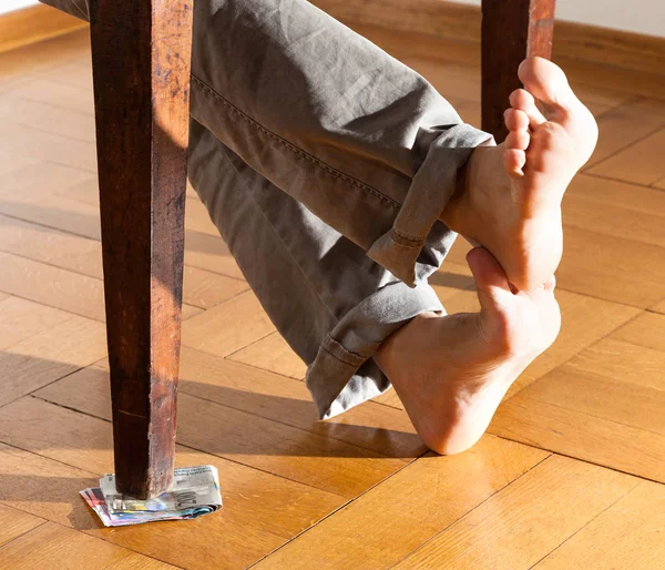 Στα Πόδια Του Ένας Άνθρωπος Κάτω Από Τραπέζι Πάτωμα Παρκέ — Φωτογραφία Αρχείου