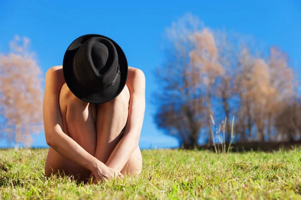 Naken flicka med hatt hopkrupen — Stockfoto