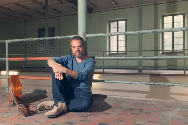 Mann auf dem Boden sitzend, Innenraum — Stockfoto