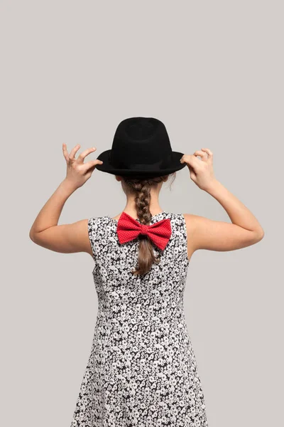 Girl with red bow and black hat — Stock Photo, Image