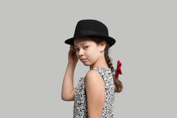 Dívka s červenou mašlí a černý klobouk — Stock fotografie