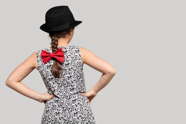 Girl with red bow and black hat — Stock Photo, Image