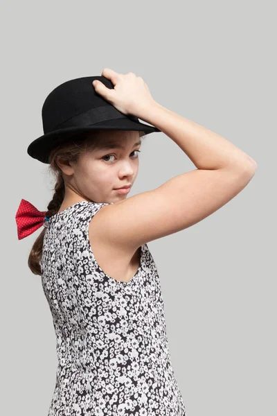 Ragazza con fiocco rosso e cappello nero — Foto Stock