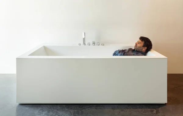 Interiör, vitt badkar med man — Stockfoto