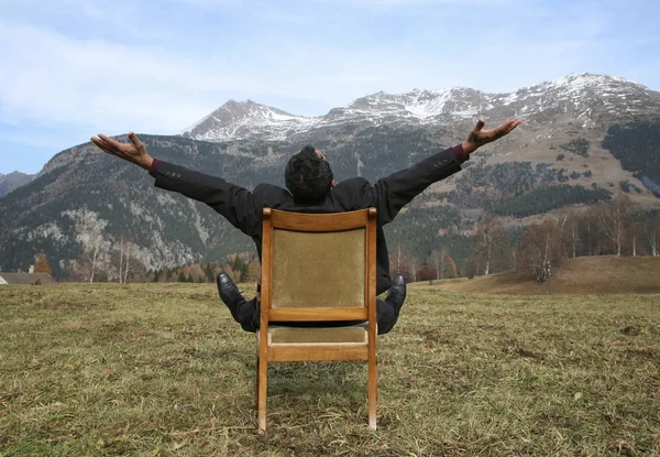 O homem da liberdade senta-se em uma cadeira no selvagem — Fotografia de Stock