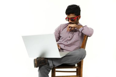 genç adam portre bir sandalyede oturan dizüstü bilgisayar ile çalışma