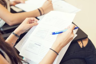 Kız öğrenci ders, omuzdan ayrıntılı notlar alır