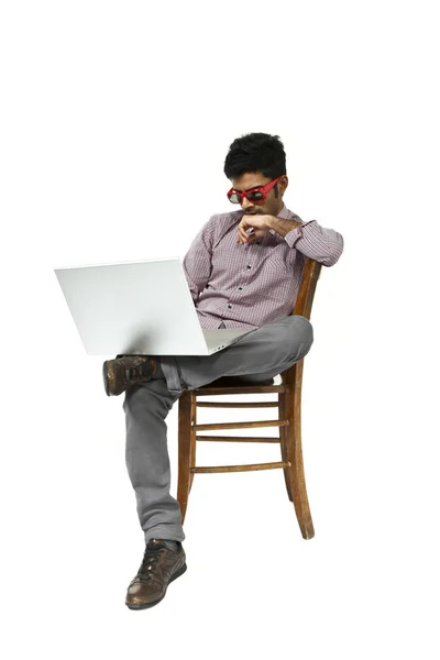 若い男の肖像画が椅子に座ってノート パソコンを操作 — ストック写真