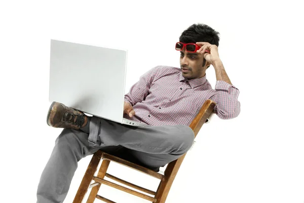 Retrato jovem trabalhando com o laptop sentado em uma cadeira — Fotografia de Stock