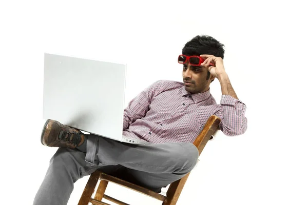 Ritratto di giovane uomo che lavora con il computer portatile seduto su una sedia — Foto Stock