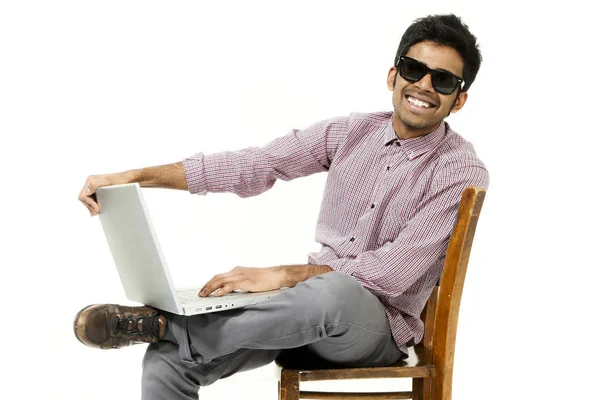 Ritratto di giovane uomo che lavora con il computer portatile seduto su una sedia — Foto Stock