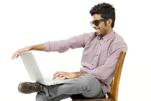 Portrait de jeune homme travaillant avec l'ordinateur portable assis sur une chaise — Photo