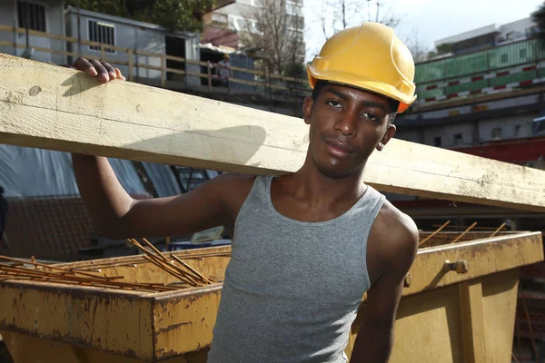 Jonge Afrikaanse man aan het werk in de bouwplaats — Stockfoto