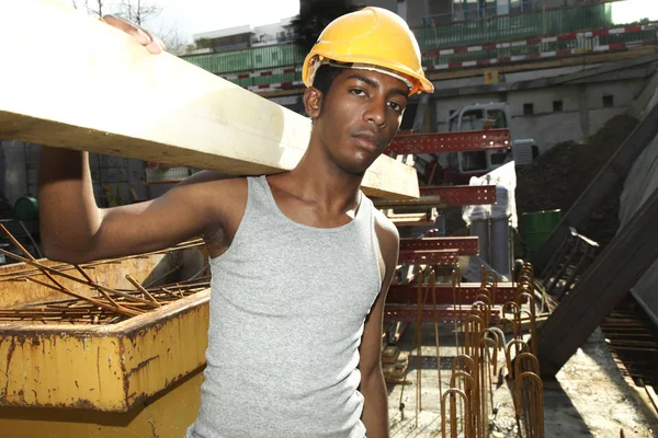 Jonge Afrikaanse man aan het werk in de bouwplaats — Stockfoto