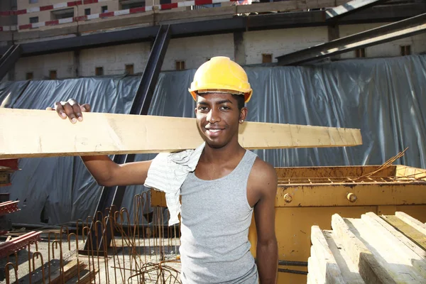 Jonge Afrikaanse man aan het werk in de bouwplaats — Stockfoto
