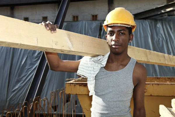 Jonge Afrikaanse man aan het werk in de bouwplaats — Stockfoto