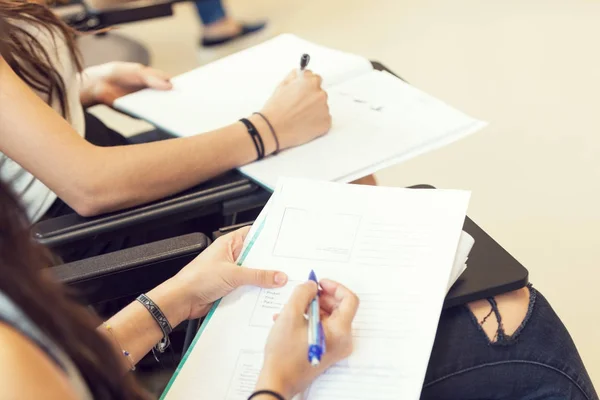 Chica estudiante toma notas de la lección, detalle desde el hombro — Foto de Stock