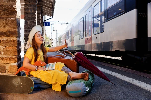 Kleines Mädchen wartet in einem verlassenen Bahnhof auf den Zug, Sommer — Stockfoto