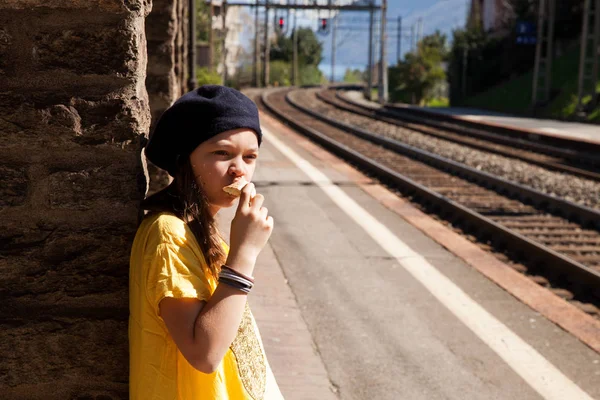 Liten flicka väntar på tåget i en övergiven station, sommaren — Stockfoto