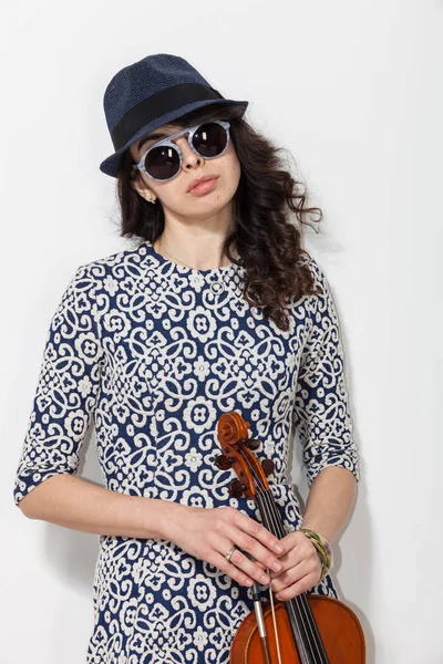 Mujer joven con gafas oscuras y un violín en la mano — Foto de Stock