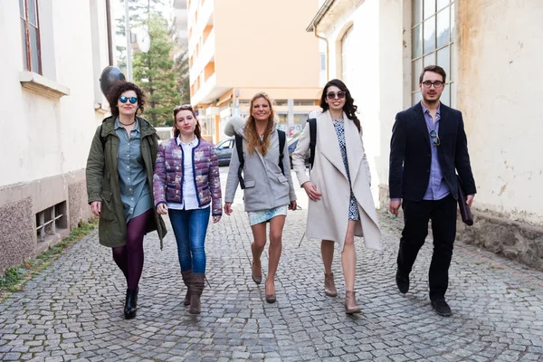 five musicians walk along the avenue