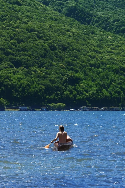 Boy with canoe on lake — Stock Photo, Image