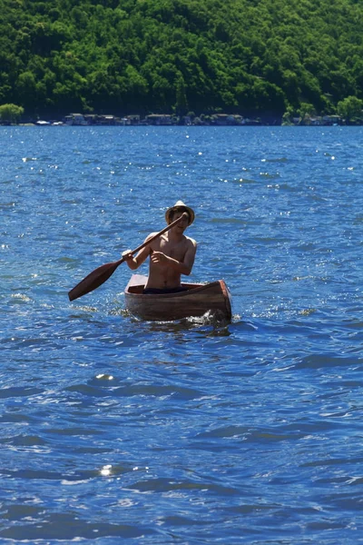 Chłopiec z canoe nad jeziorem — Zdjęcie stockowe