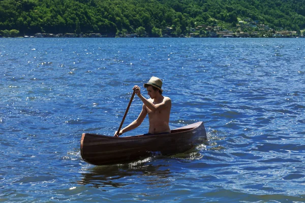 Menino com canoa no lago — Fotografia de Stock