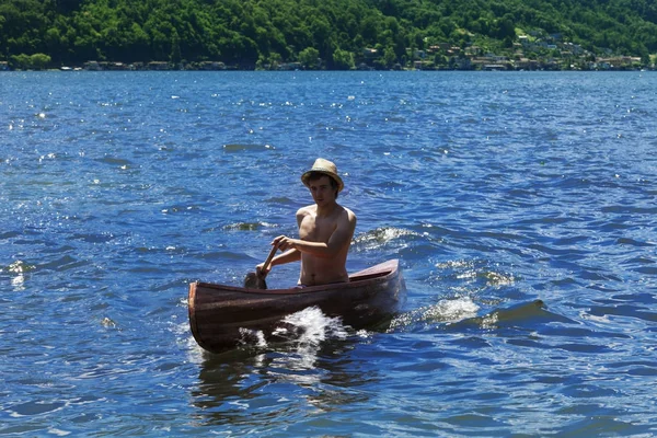 Boy with canoe on lake — Stock Photo, Image