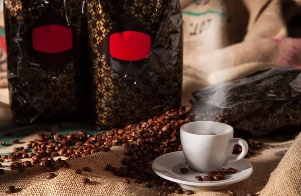 Tasse Kaffee mit gerösteten Bohnen, Stillleben — Stockfoto