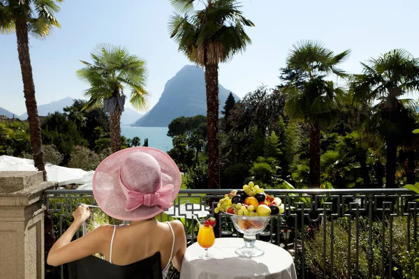 Sommaren kvinna stående på en lyx terrass vid sjön — Stockfoto