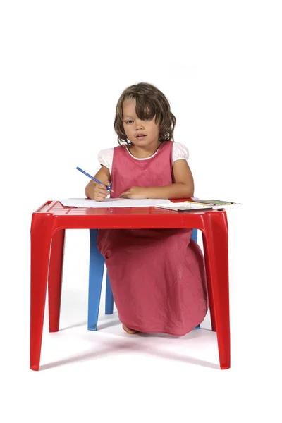 Junges studentisches Mädchen mit kleinem roten Schreibtisch — Stockfoto