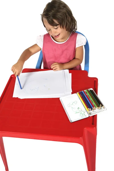Joven estudiante con pequeño escritorio rojo — Foto de Stock
