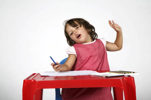 Jovem estudante menina com pequena mesa vermelha — Fotografia de Stock