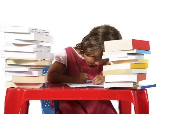 Joven estudiante con pequeño escritorio rojo —  Fotos de Stock