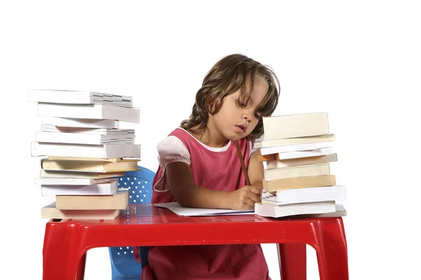 Joven estudiante con pequeño escritorio rojo —  Fotos de Stock