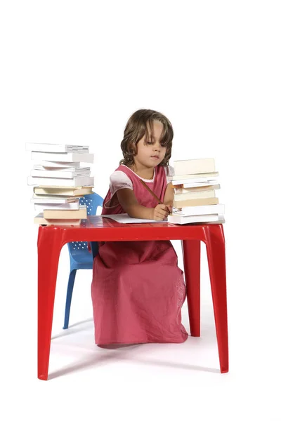 Молодая студентка с маленьким красным столом — стоковое фото