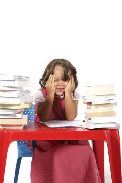 Joven estudiante con pequeño escritorio rojo —  Fotos de Stock