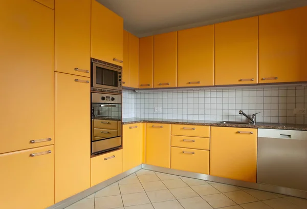 Кухня с оранжевой мебелью и плиткой — стоковое фото