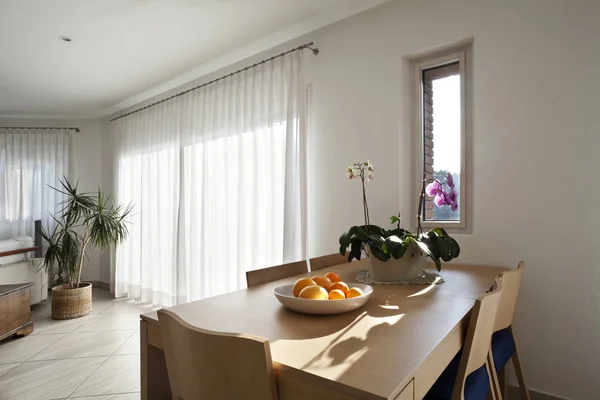 Moderne Wohnungseinrichtung: Holztisch mit Blumen und Früchten — Stockfoto