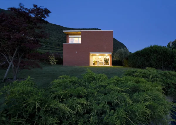 Casa in mattoni, vista dal giardino, notte — Foto Stock